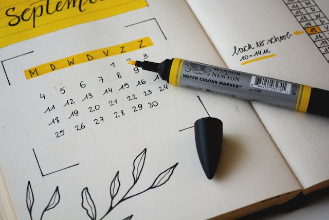 A photo of a personal planner, opened to a page showing a simple calendar with dates crossed out.