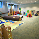 Thumbnail: A slightly open area with many tactile and interactive learn-and-play items scattered throughout.