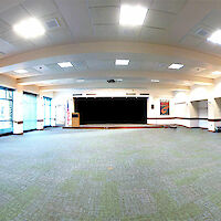 A wide view of nearly the full physical space of the room with the platform stage as the focus.
