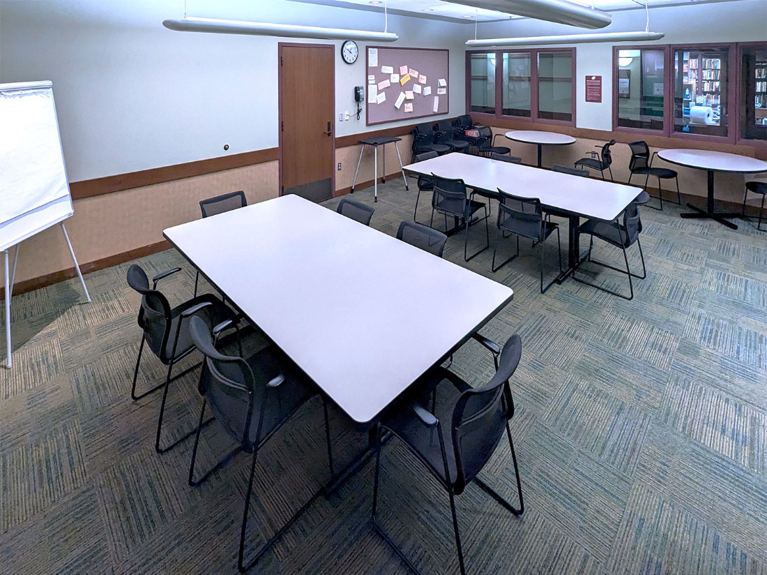 Looking to the back-right from the far left. The bulletin board and three tables can be seen.