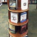 Thumbnail: 8 books displayed on a round, wooden shelf-end, vertically. There are 4 shelves with two books each.