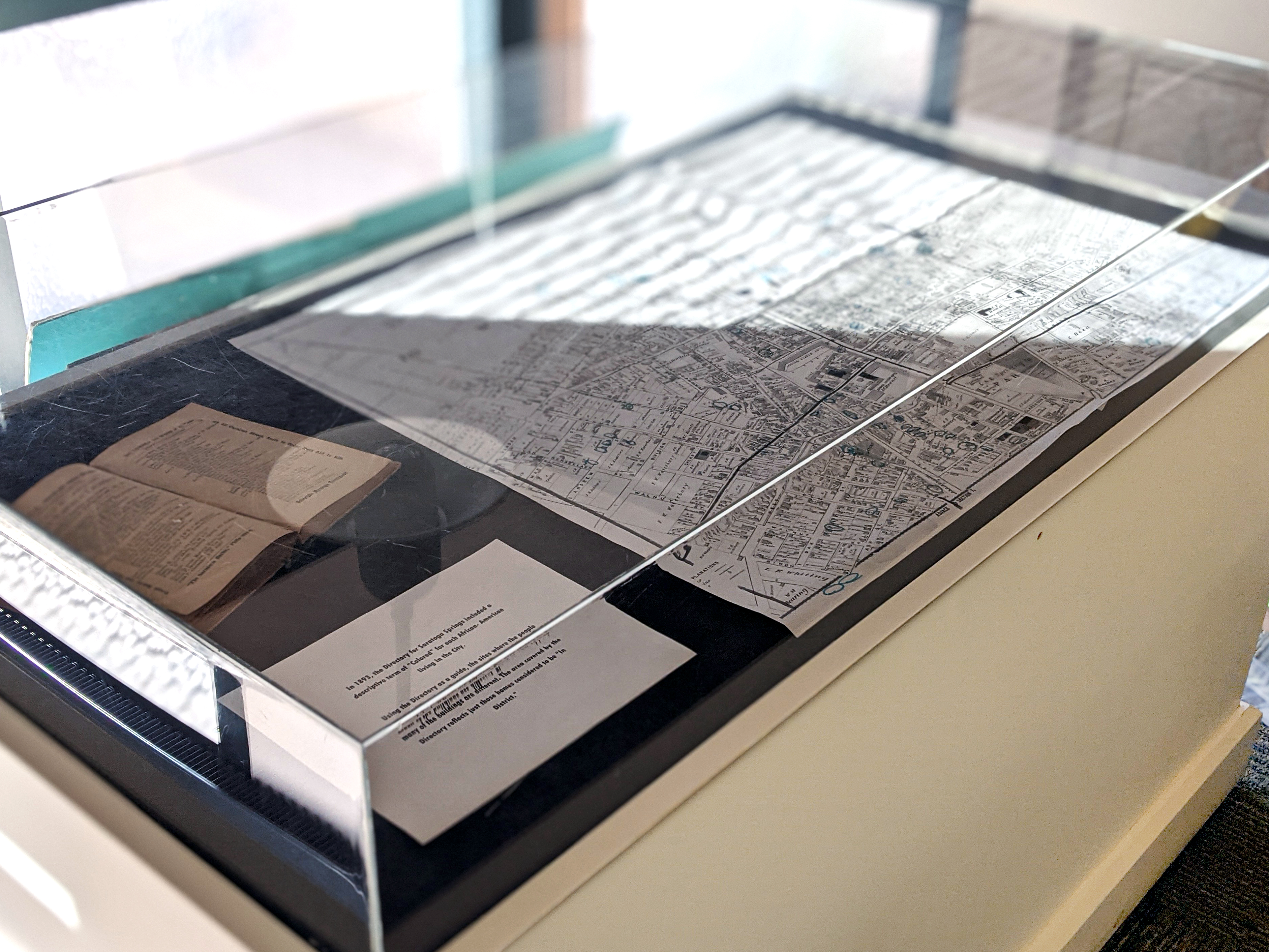 Glass-topped display case protecting historic items as well as an historical map.