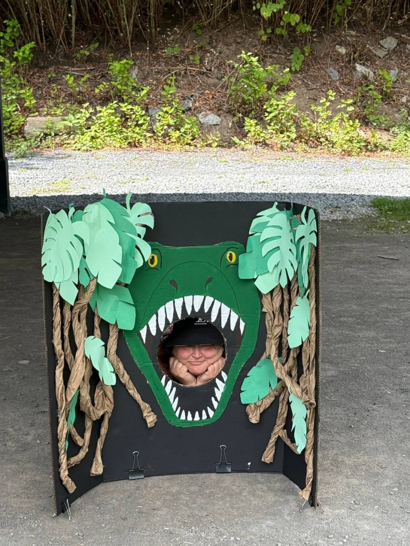 librarian poses in a dinosaur photo booth