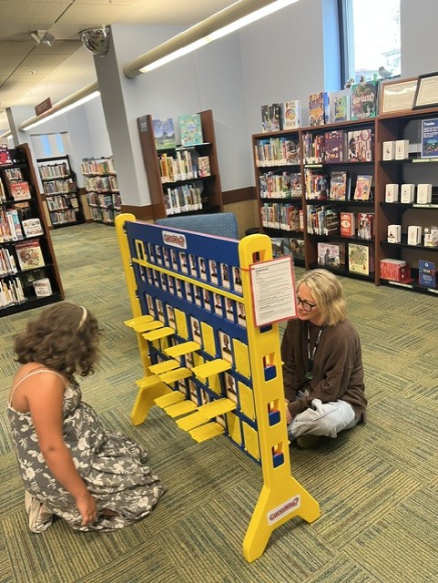 a large guess who game is being played by library patrons