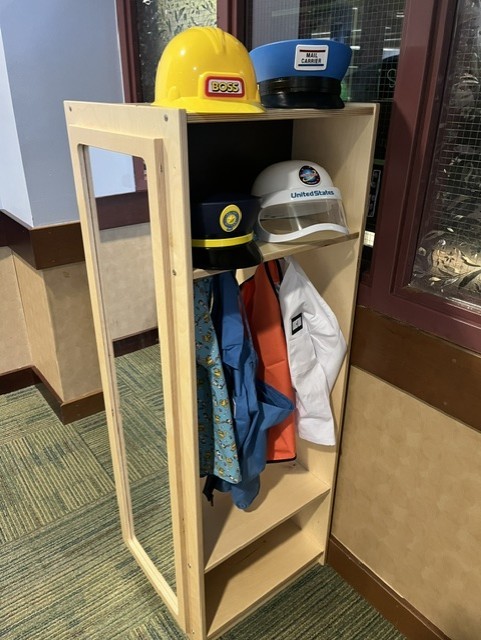 children’s dress up station with costumes on it