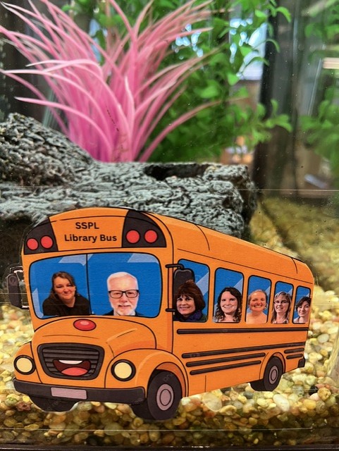 Photos of library staff have been photoshopped into a cartoon school bus