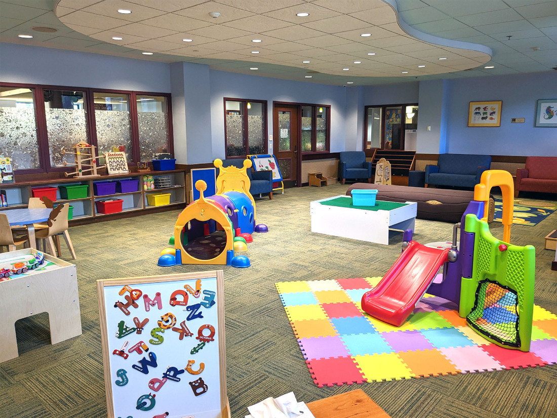 A magnetic alphabet letter board, indoor miniature playground-like area, and various other interactive play items.