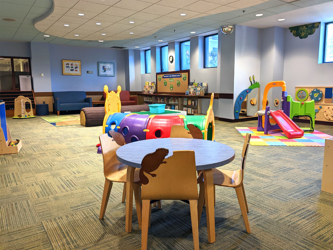 Four decorative, nature-themed, wooden chairs surround a table in the center of the room.