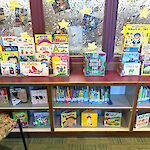 Thumbnail: A three-tiered shelving of children’s books arranged for display.