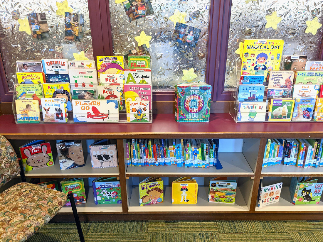 A three-tiered shelving of children’s books arranged for display.