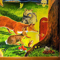 Animals in a forest at night crowd around an open door attached to a tree trunk in the forest, with brilliant light coming forth from the doorway.