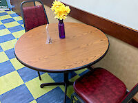 Two red, leather-cushioned seats surround a small circular table with a floral centerpiece.