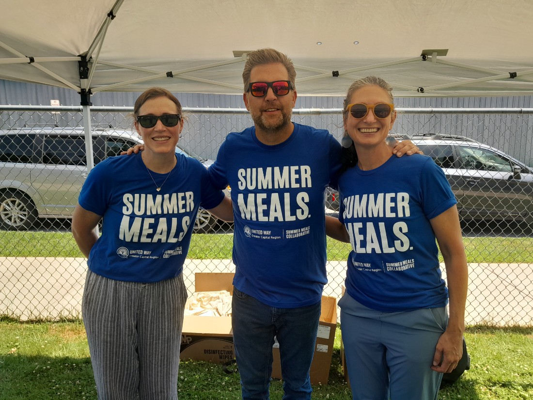woman next to man next to another woman.  all in blue t-shirts with the words summer meals written on the t-shirts